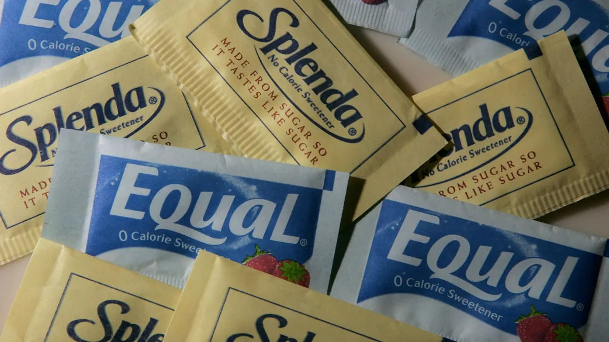 Packages of Equal and Splenda artificial sweeteners are displayed at a coffee shop