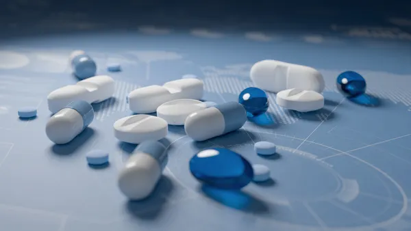 Pills, tablets and capsules on world map with charts blue background