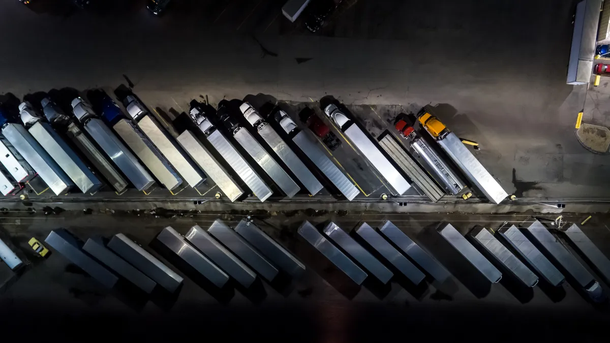 Aerial shot looking directly down on a row of trucks parked at a truck stop near Albuquerque, New Mexico at night.