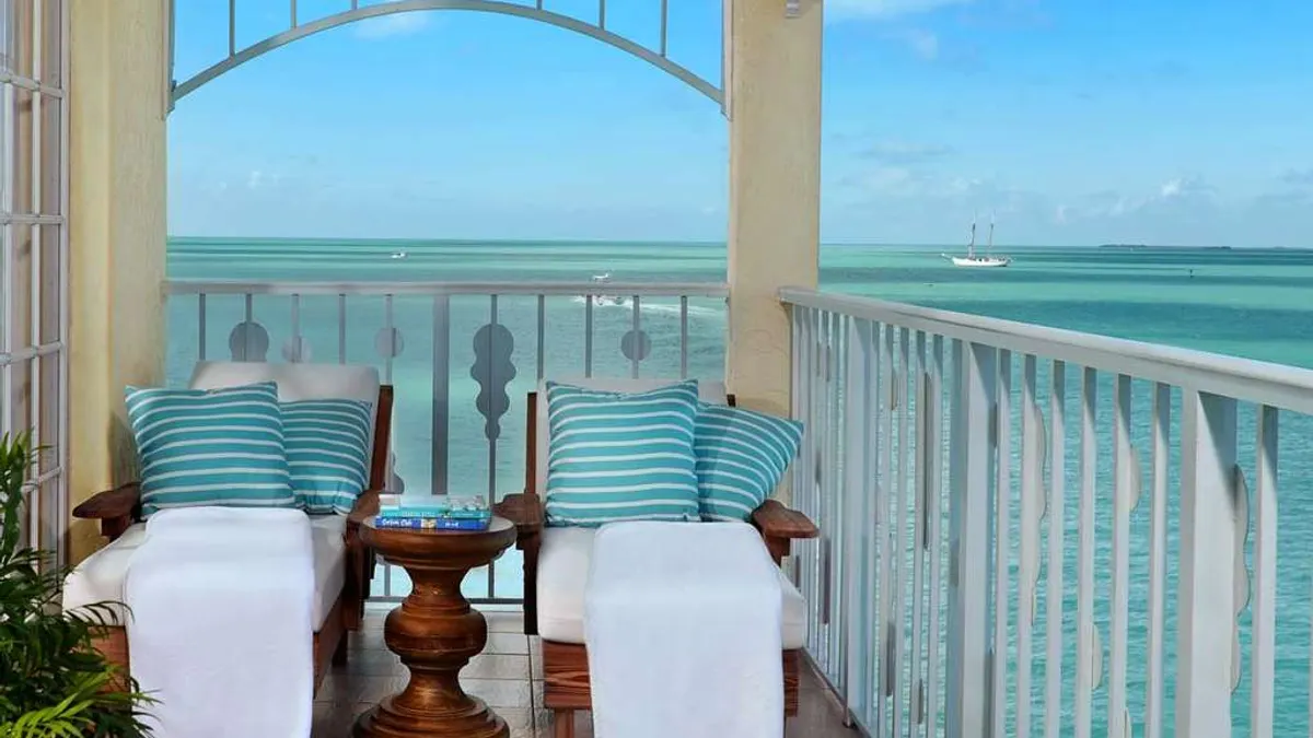 Two chairs on a deck overlooking the ocean.