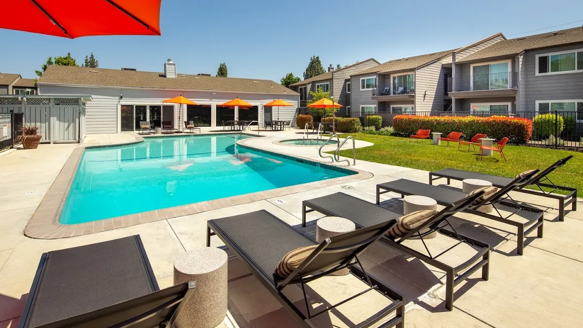 Two-story apartments and a clubhouse surrounding a pool.