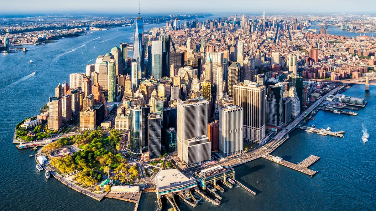 Aerial shot of skyscrapers and city buildings surrounded by water