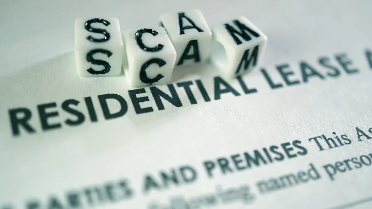 the word scam spelled in dice above a residential lease