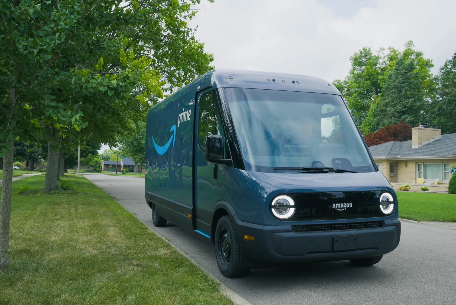 An Amazon delivery van made by Rivian sits in a neighborhood.