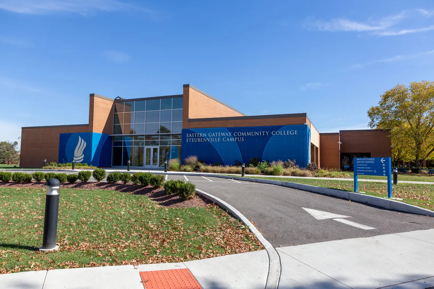 A brick-and-glass building is wrapped in a blue sign reading "Eastern Gateway Community College Steubenville Campus."