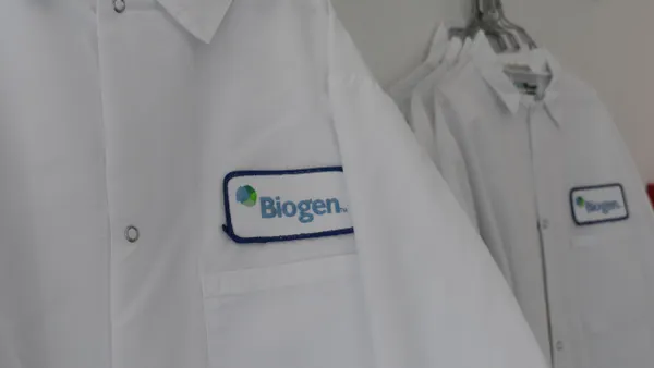 Lab coats embroidered with the Biogen logo are hung on a wall of a lab in the company's Cambridge, Massachusetts, headquarters on Sept. 5, 2024.