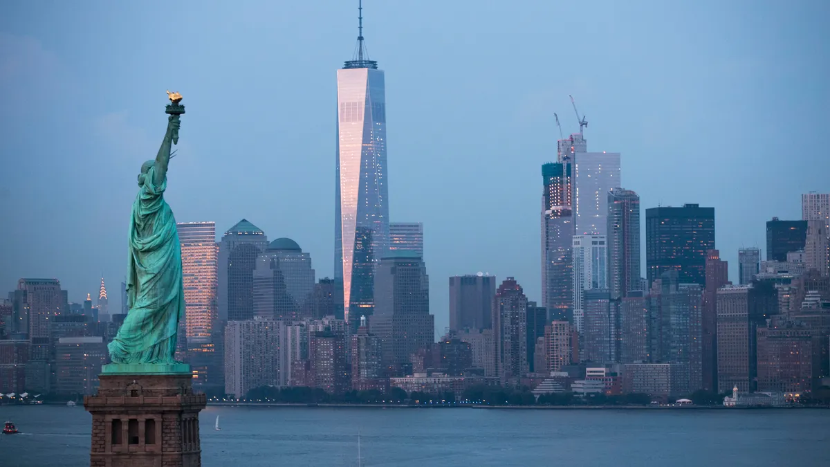 The Statue of Liberty stands in the foreground as Lower Manhattan is viewed at dusk, September 8, 2016 in New York City