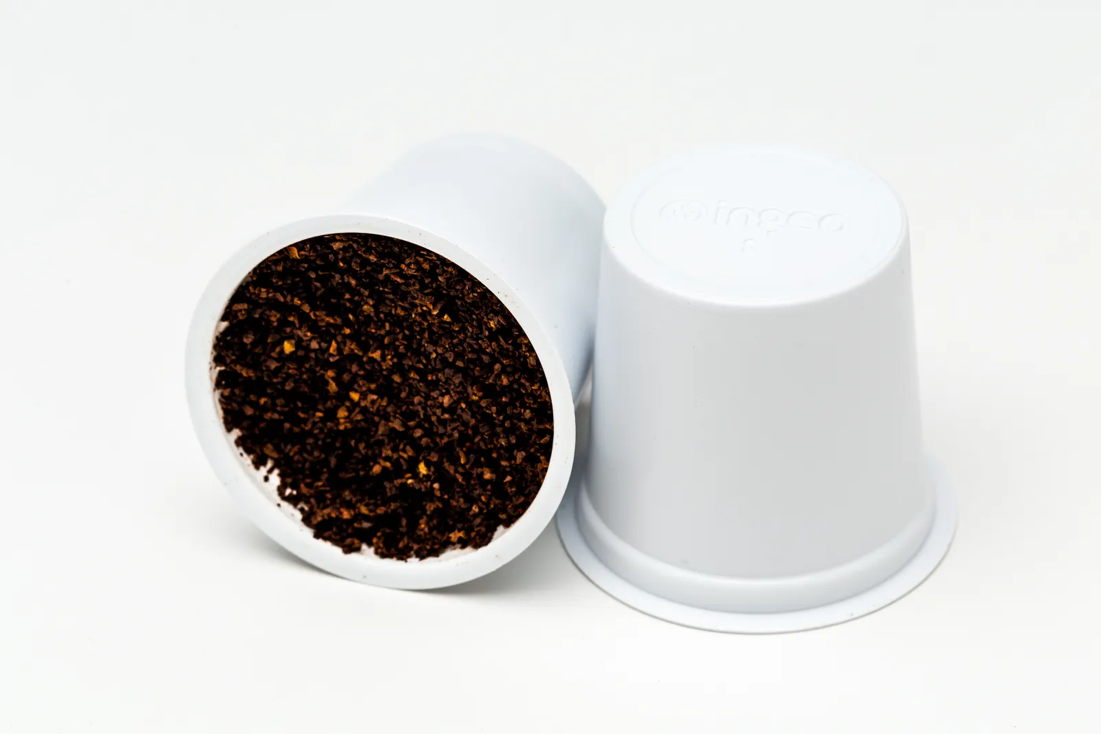 White compostable coffee pod with coffee grounds inside