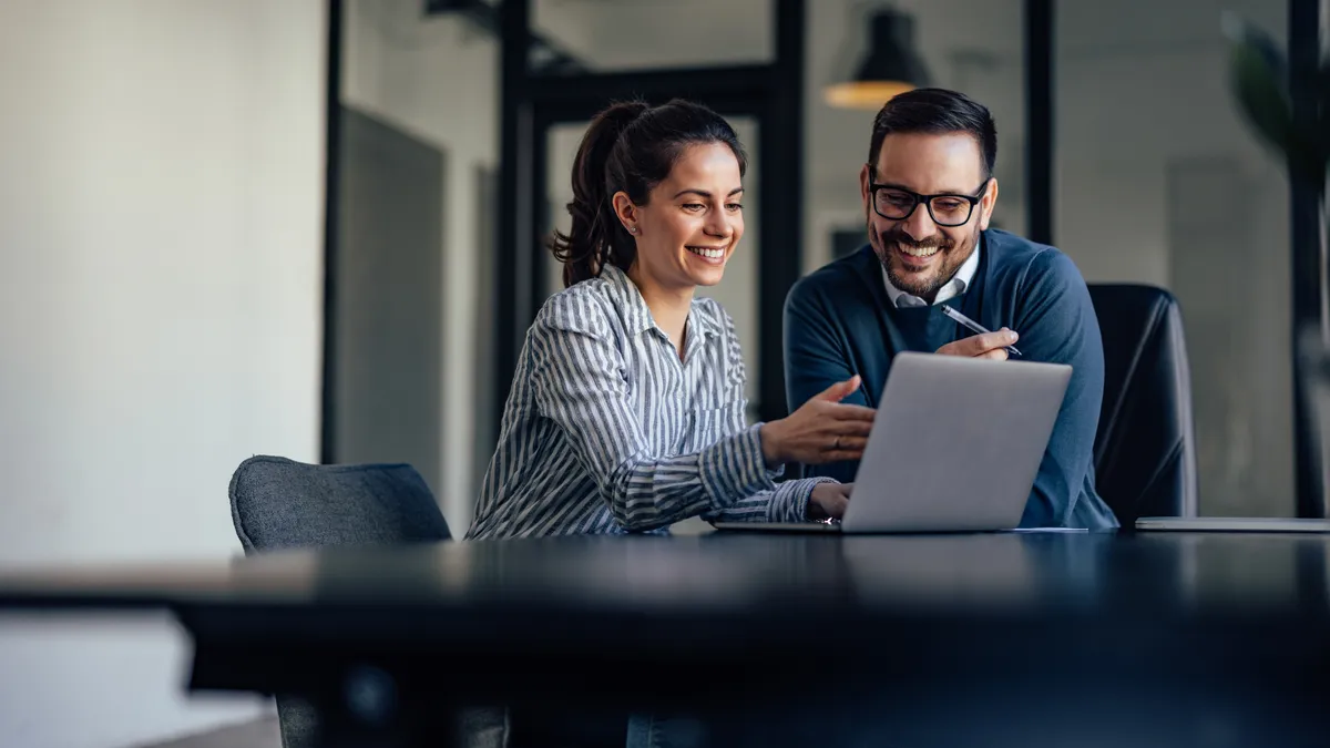 Portrait of two business colleagues, looking at something online