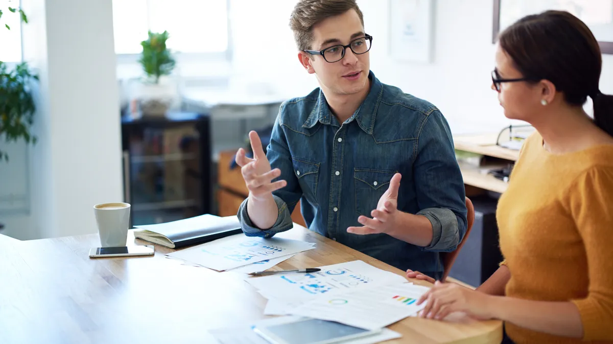 Two coworkers having a discussion in the office