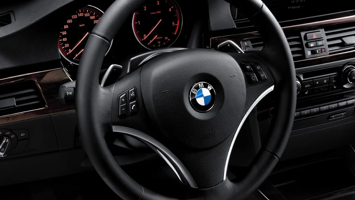 The black steering wheel in a model year 2010 BMW 3-Series.