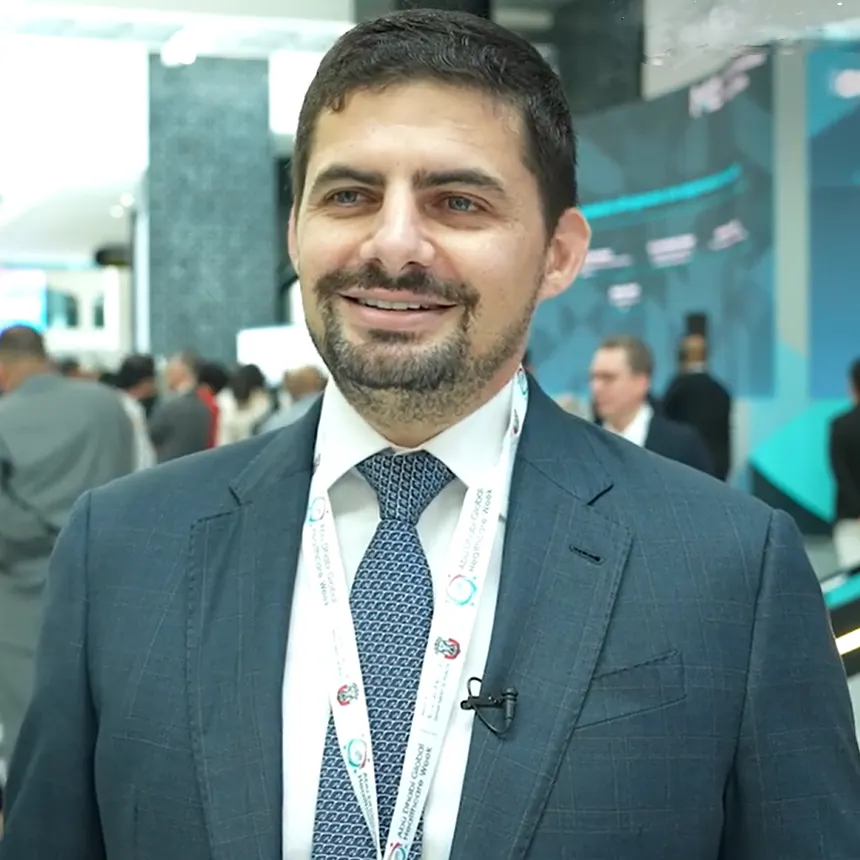 XCath CEO Eduardo Fonseca with conference attendees in the background.