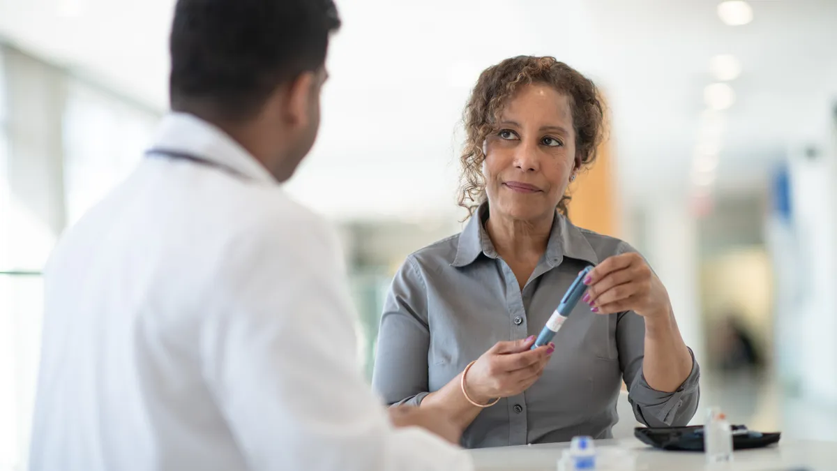 A woman discusses with her doctor about possibilities for diabetes treatment in a well lit medical facility.