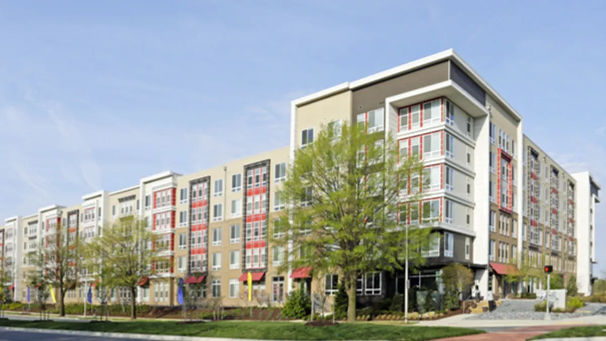 Modern brick apartment building next to street.