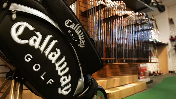 A Callaway Golf bag stands in the foreground and rows of clubs are the background.