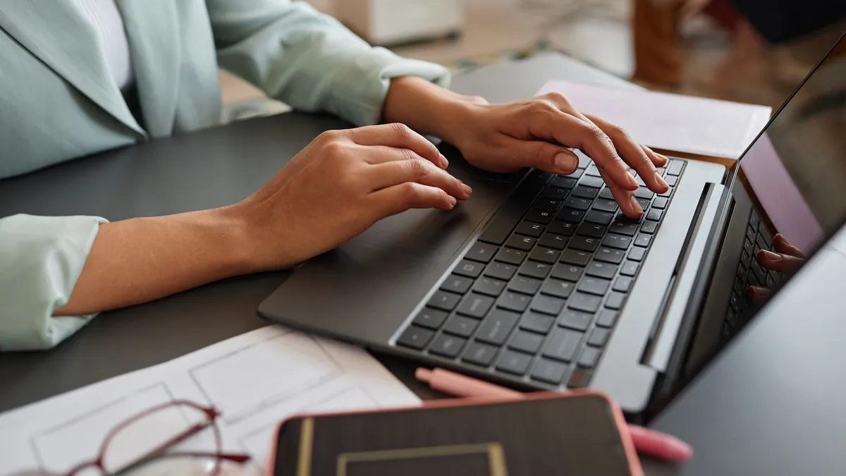 close up of a woman typing on a laptop