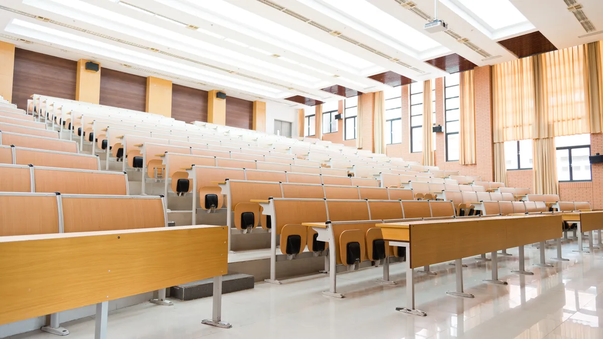 College lecture hall with large group of seats.