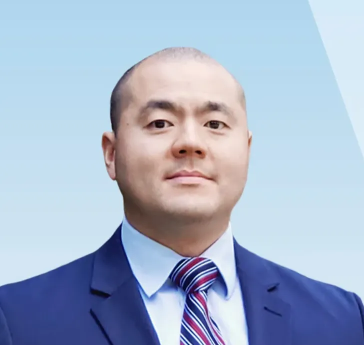 Headshot of an asian man with a striped tie and a blue suit.