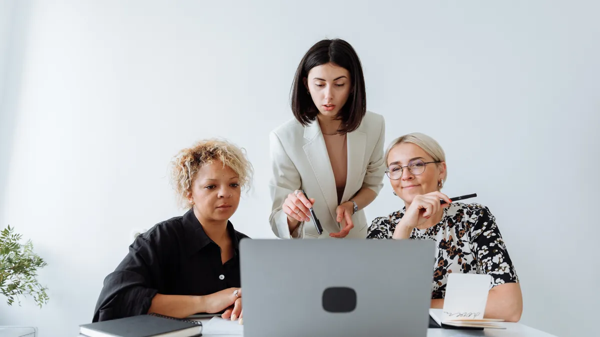 Three employees work together in an office