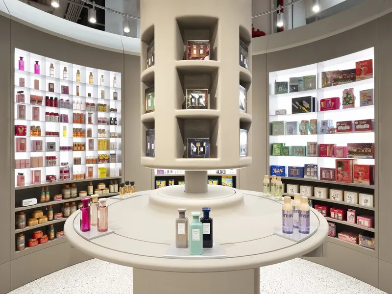A circular display of beauty products, with shelves of products in the background.