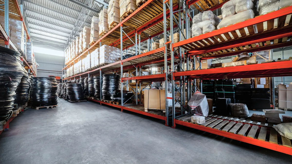 Construction materials sit on shelves in a warehouse.