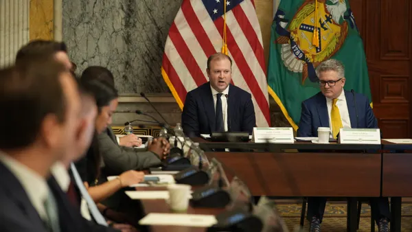 Men in suits sit at a table.