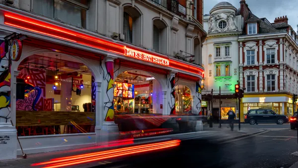 A photo of a Dave's Hot Chicken location in London. Taken with a long exposure, the photo has motion trails from car lights.