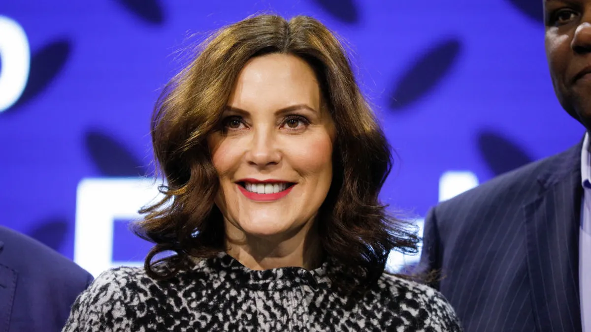 Woman stands in group in front of screen