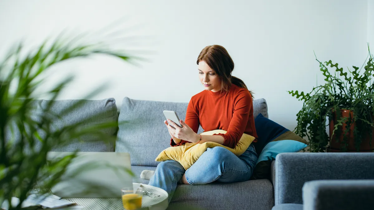 A person looks at their phone while working from home.