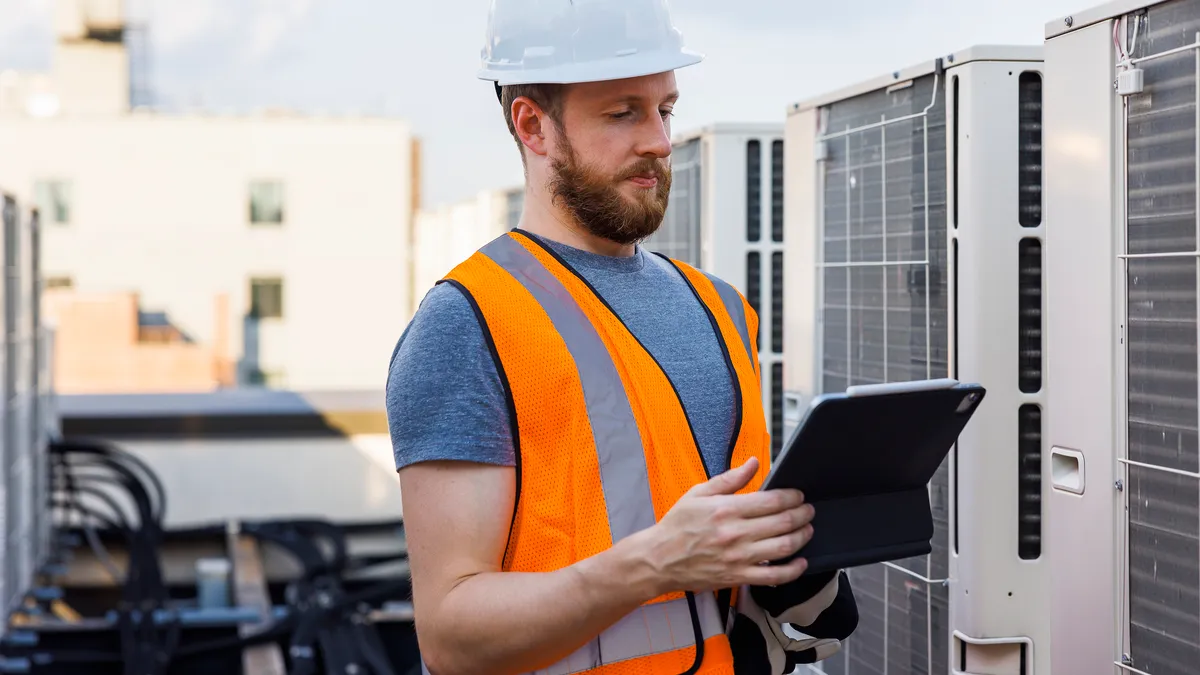 A technician checks the air conditioning system, using a portable computer.