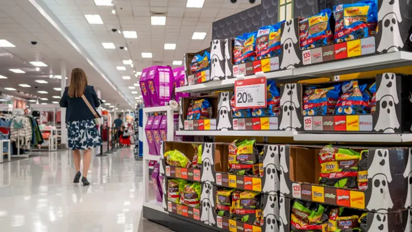 A person is shopping in a Target near shelves of Halloween candy.