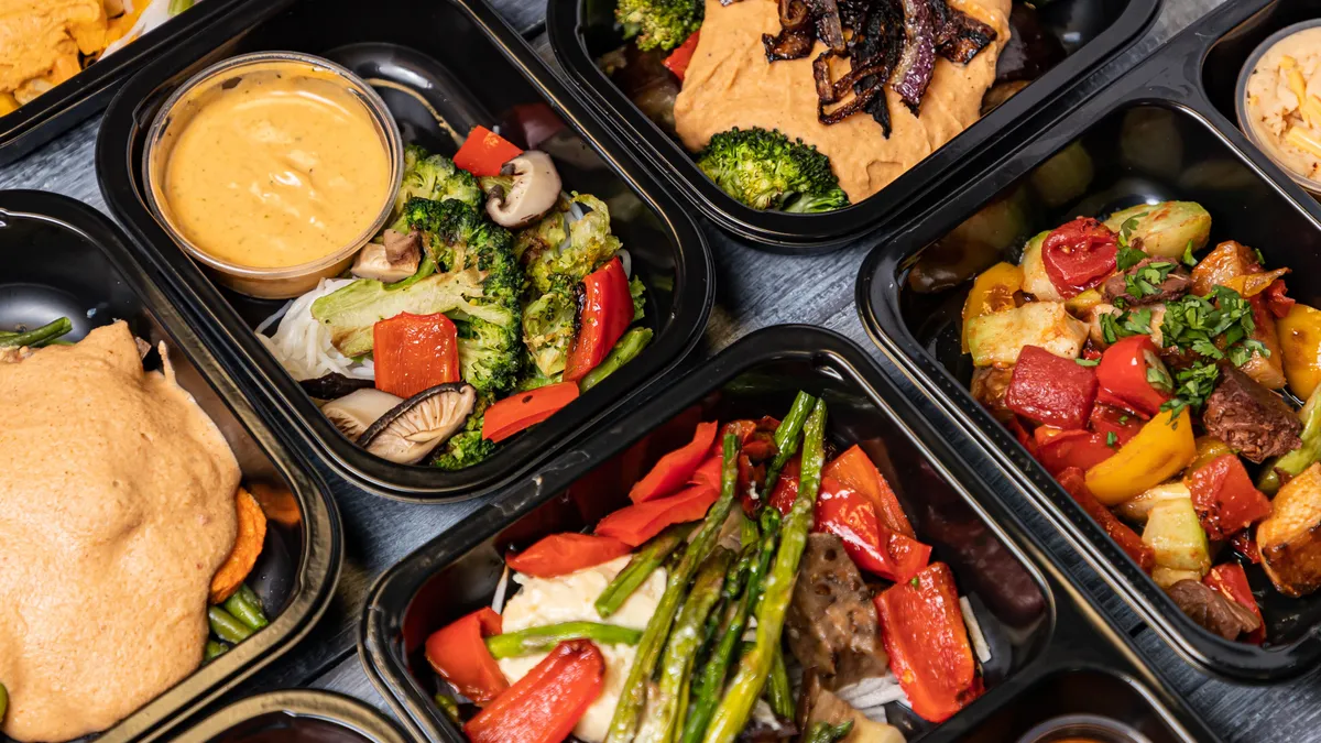 Cooked vegetables in black plastic containers