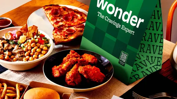 A photograph of a selection of food items, including pepperoni pizza, chicken wings and burgers next to a green checkered back with wording that says Wonder The Cravings Expert.
