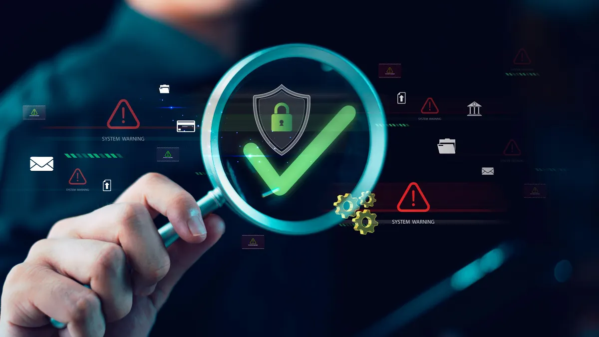 A hand holds a magnifying glass over a digital shield with a padlock and green checkmark, representing cybersecurity and risk management.