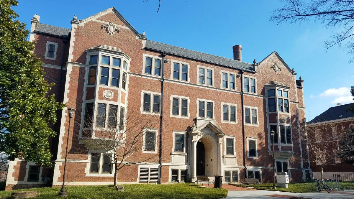 Brick three-story building seen from the front.