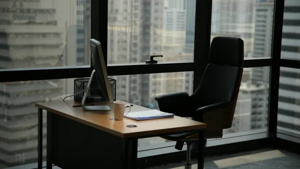 Office with a large window. Empty desk with computer.