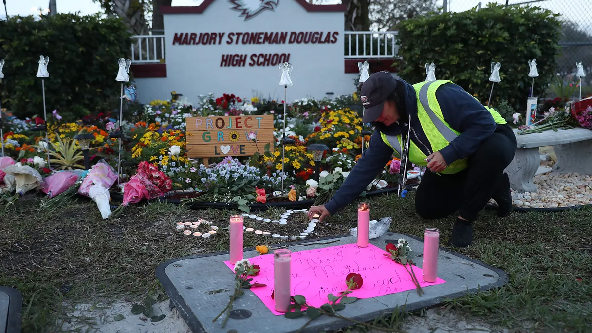 A school crossing guard pays her respects at a memorial setup for those killed on February 14, 2018, at Marjory Stoneman Douglas High School in Parkland, Florida.