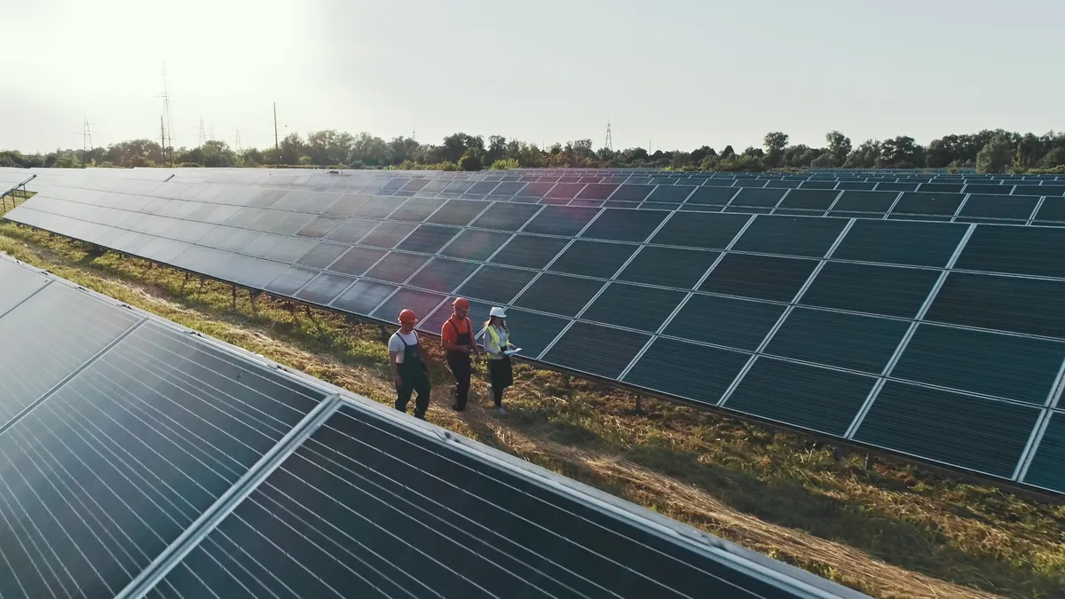 Specialists walking across a solar power plant.