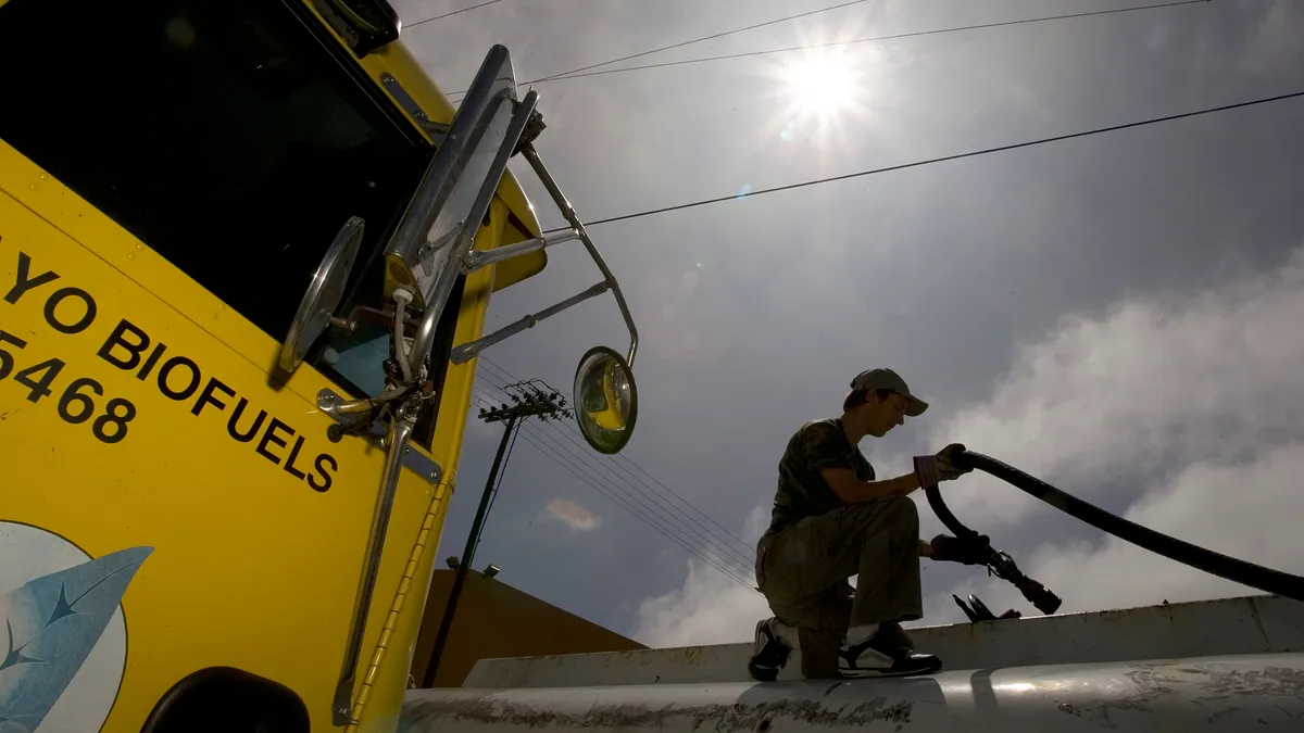 A man fills up a fuel truck with biodiesel.