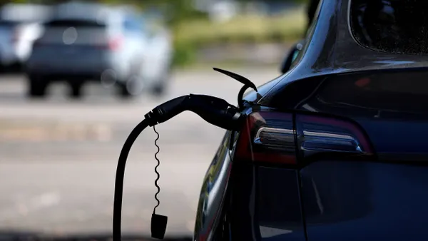 A Tesla car sits parked at an electric vehicle charging station