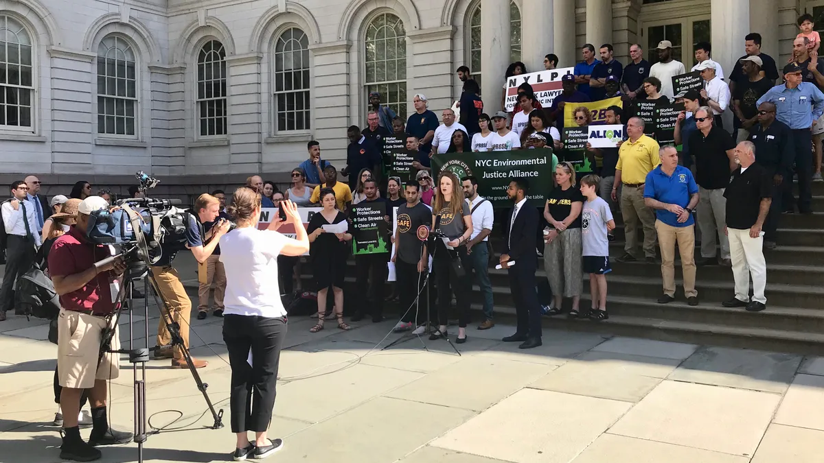 A group of people rally on the steps of New York City Hall