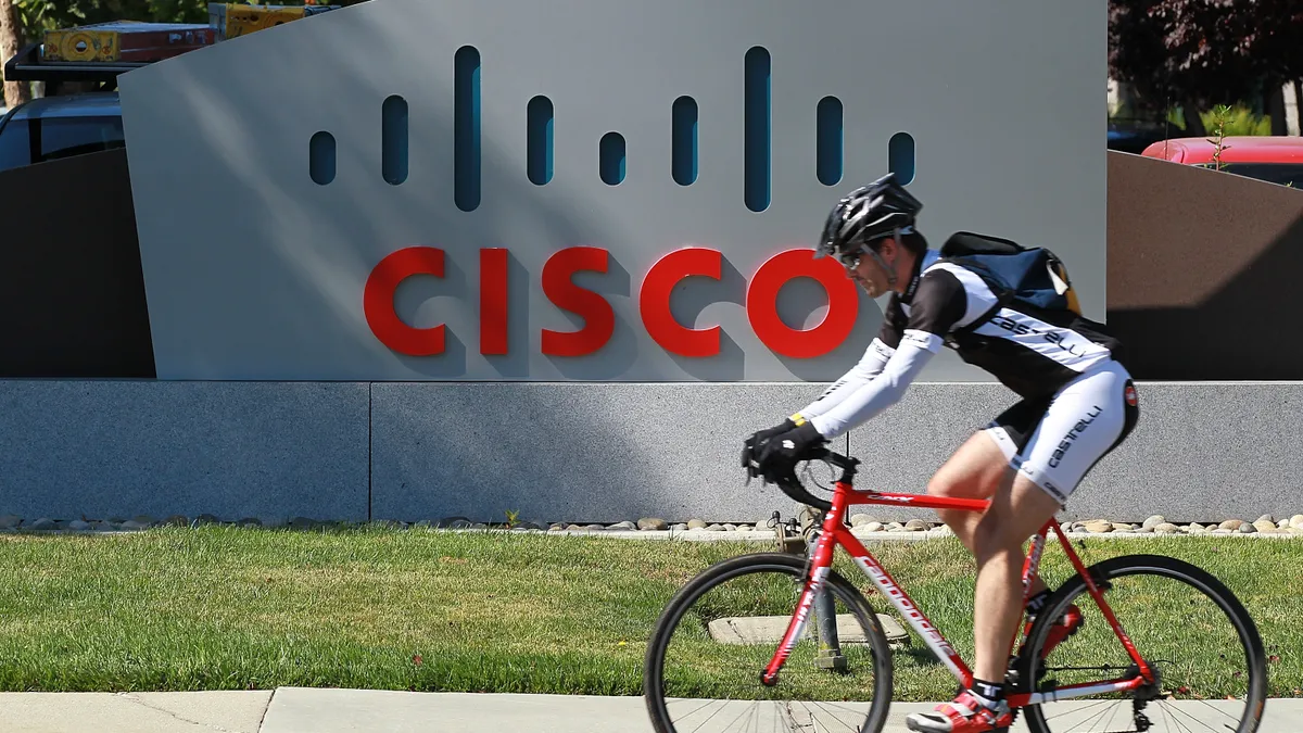 A bicyclist rides by a sign that is posted in front of the Cisco Systems headquarters on August 10, 2011 in San Jose, California.