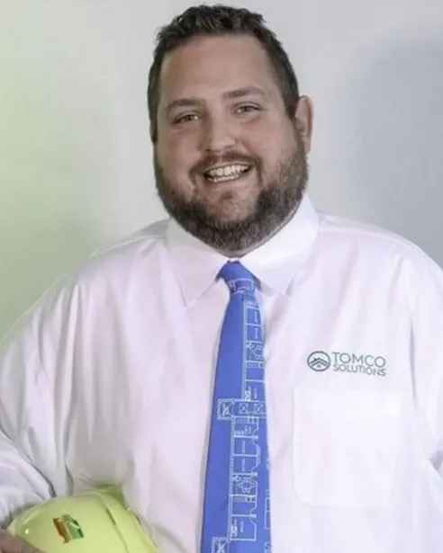 Headshot of a smiling man in a white collared shirt.