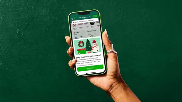 Close-up of a hand holding a phone against a dark green backdrop