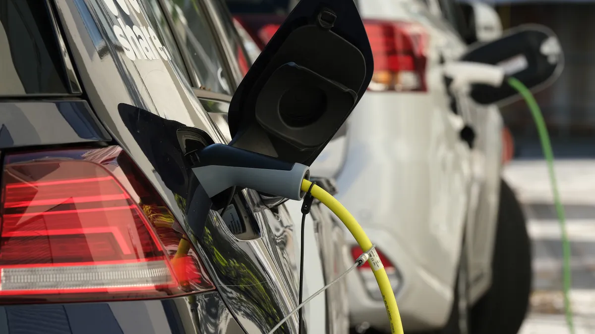 Closeup of a blue and silver car charging.