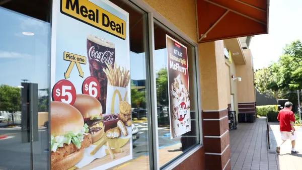 An image of a sign that says $5 Meal Deal on a window of a McDonald's