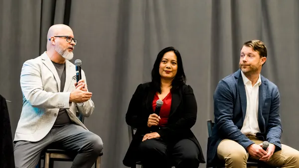 Paul Nowak, Cheryl Lam and Matt Swenson sit on stage