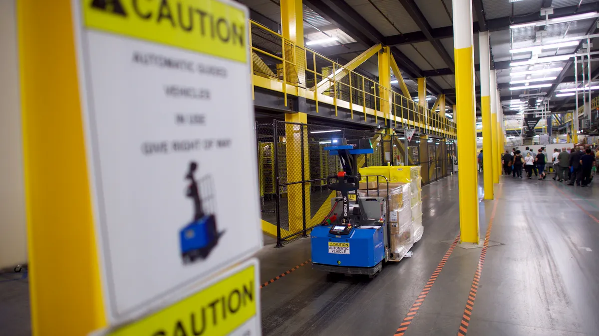 A robotic machine moves through a warehouse.