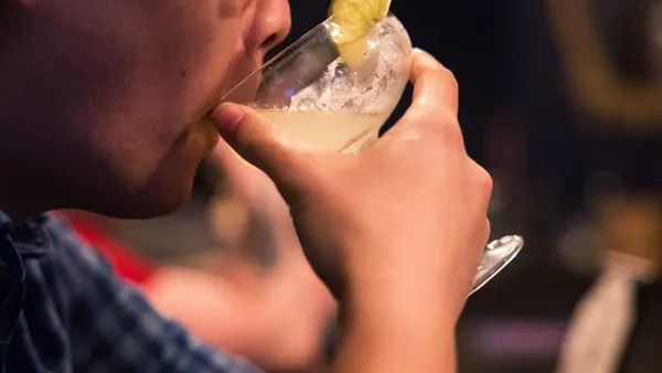 A close up of a man drinking a non-alcoholic cocktail