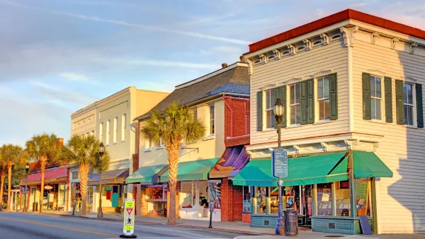 Two-story buildings with awnings line a street.